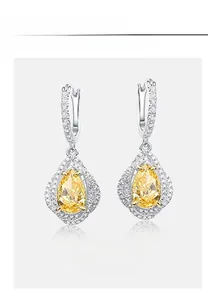 Détail de boucles d'oreilles en diamant jaune taille poire et crochets en argent S925