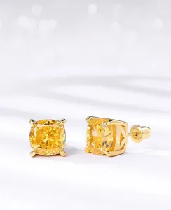 Macro view of ice-cut yellow carbon diamond earrings with four-prong silver setting