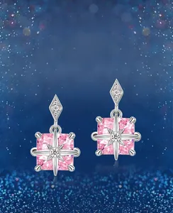 Close-up of pink square-cut high carbon diamond earrings with silver starburst details