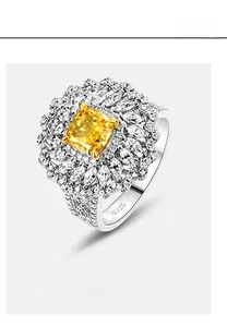 Gros plan d'une bague en argent S925 avec pierre jaune taille coussin et halo serti