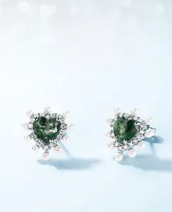 Gros plan de boucles d'oreilles cœur en agate mousse avec bordure en perles et zircons fins
