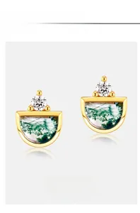 Macro shot of silver stud earrings with green moss agate and sparkling carbon diamonds