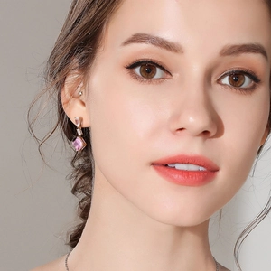 Luxury S925 silver square pink carbon diamond earrings worn by a model in close-up view