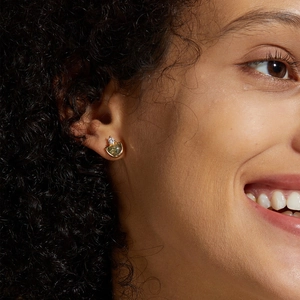 Close-up of S925 silver moss agate stud earring with a sparkling diamond detail on model