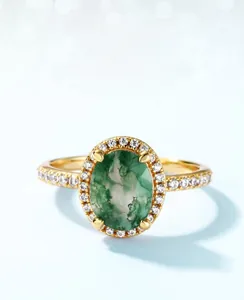 Close-up of oval green moss agate ring with diamond halo and gold plated band