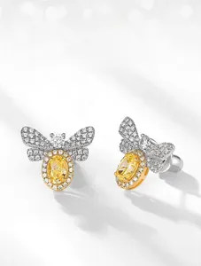 Macro shot of silver bee earring featuring a yellow carbon diamond and sparkling wings