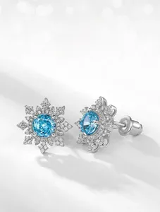 Gros plan sur les boucles d'oreilles flocon en argent S925 et diamants bleus