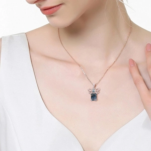 Detail of rose gold S925 silver necklace with moss agate pendant on a female model
