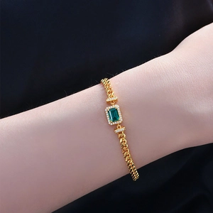 Goldenes Armband mit grünem Smaragdschliff-Stein und Zirkonia-Halo auf Panzerkette