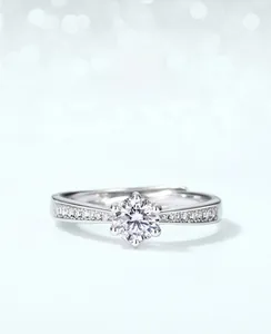 Macro view of a moissanite ring showing a six-prong crown setting and paved diamonds