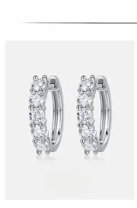 Detailed view of silver hoop earrings featuring five round moissanite stones in a row