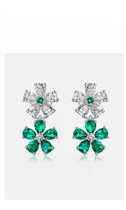 Detail of flower earrings with emerald green gemstones and sparkling white crystals