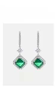 Close-up of S925 silver earrings with square emerald gemstones and sparkling accent stones