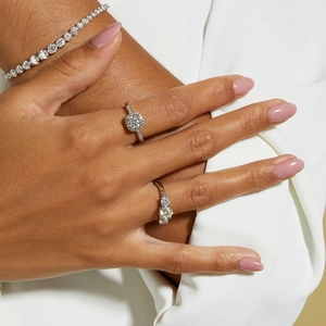 Close-up of a S925 sterling silver moissanite ring set and tennis bracelet on a model hand