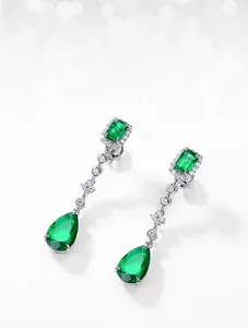 Detail of lab-grown emerald earrings with square and pear cut stones on S925 silver chain
