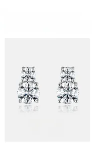 Macro detail of stacked round-cut moissanite stud earrings in sterling silver