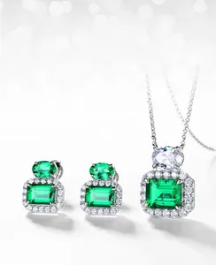 Detail of lab-grown emerald jewelry set featuring horizontal emerald-cut stones and halo setting