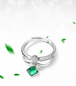 Macro de la bague émeraude de synthèse carrée avec pavage de diamants étincelants