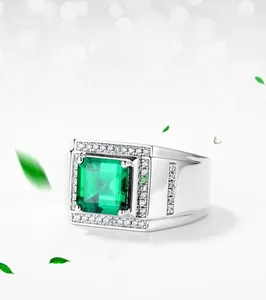 Macro shot of emerald cut lab-grown emerald ring with pave-set diamond details on band