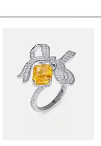 Macro detail of S925 silver bow ring featuring a square yellow lab emerald and pavé stones