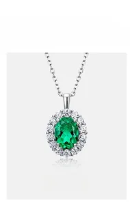 Macro shot of oval-cut lab emerald pendant with sparkling halo setting and silver chain