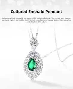 Detailed close-up of pear-cut lab emerald pendant with halo zircon setting in silver