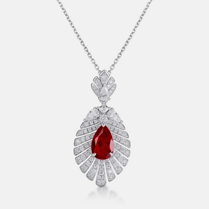 Detailed view of pear-cut ruby pendant with micro-paved diamonds in silver setting