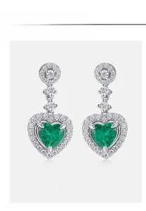 Close-up of heart-cut emerald earrings set in S925 sterling silver with diamond accents