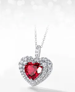 Macro view of heart-shaped pendant with red lab-grown ruby and cubic zirconia halo