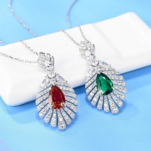 Elegant S925 silver teardrop pendants with red and green gemstones on blue display stand