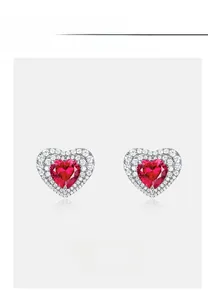 Close-up of heart-shaped ruby stud earrings with a sparkling double halo of lab diamonds
