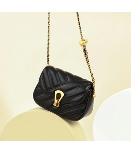 Détail du sac à rabat en cuir matelassé noir avec boucle fer à cheval dorée et chaîne