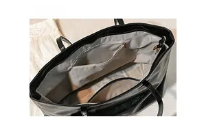 Interior view of black tote bag showing gray lining with zipper pocket and open slot