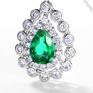 Pear-cut emerald pendant with double-halo diamond setting in S925 silver on white background