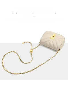 Détail de la texture cuir matelassé en V et boucle dorée sur le sac à bandoulière