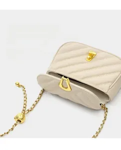 Détail du sac matelassé crème avec chaîne à bille dorée et compartiment intérieur