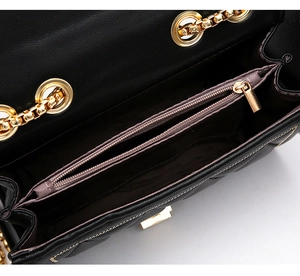 Vue intérieure du sac bandoulière matelassé noir avec poche zippée dorée et doublure