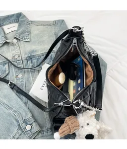 Vue intérieure du sac bandoulière matelassé noir montrant un grand espace de rangement