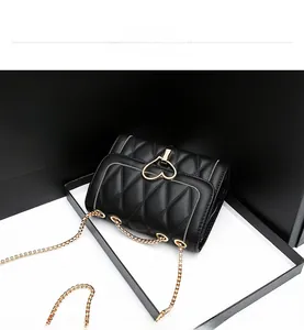 Détail macro du sac en cuir matelassé noir avec fermoir métallique en forme de cœur doré