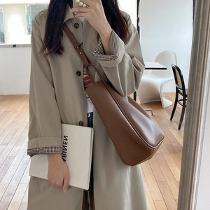Detail of adjustable leather shoulder strap on a brown retro hobo tote bag for women