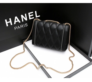 Vue macro d'un sac à bandoulière en cuir noir matelassé avec détails de chaîne dorée chic