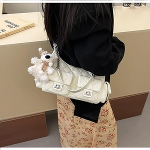 Détail du sac à bandoulière matelassé blanc avec fermoir rotatif et charmant ours peluche