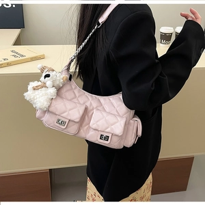 Détail du sac à bandoulière matelassé rose avec chaîne en métal et charm chien peluche