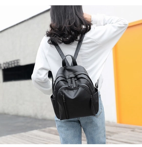 Outdoor shot of a black vintage PU leather backpack with multi-pocket and pleat design