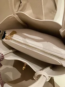Vue détaillée de l'intérieur du fourre-tout beige avec sa pochette zippée sécurisée