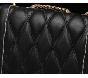 Gros plan détaillé sur le cuir matelassé noir et les coutures fines du sac à bandoulière