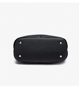 Detailed bottom view of black litchi leather bag with four gold protective metal feet