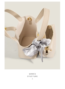 Detail of lychee pattern leather bucket bag set with silk scarf and golden hardware