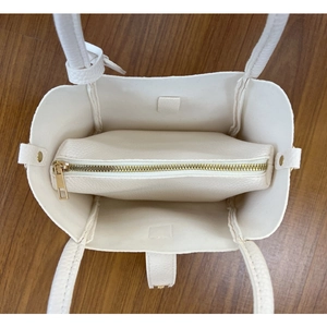 Vue de dessus du cabas crème en cuir grainé avec sa pochette intérieure zippée