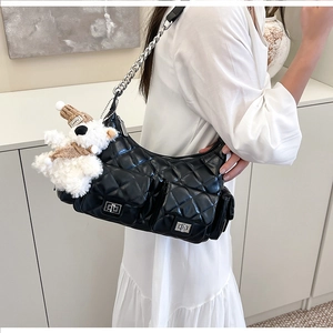Détail du sac matelassé noir avec bandoulière chaîne argentée et breloque ours en peluche